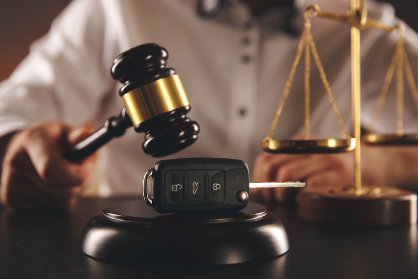 Judge gavel held over car key after car accident personal injury claim concept
