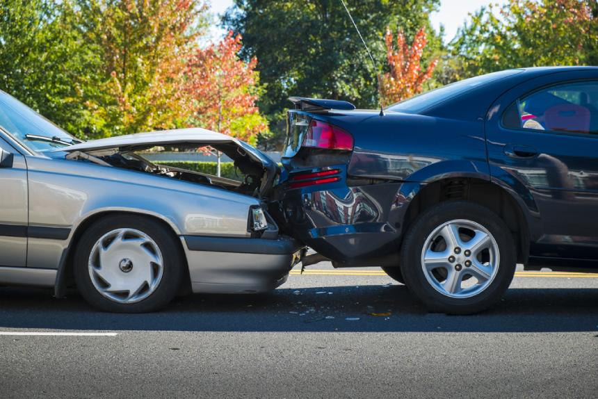 Rear end collision between gray and black car on road during fall daytime 