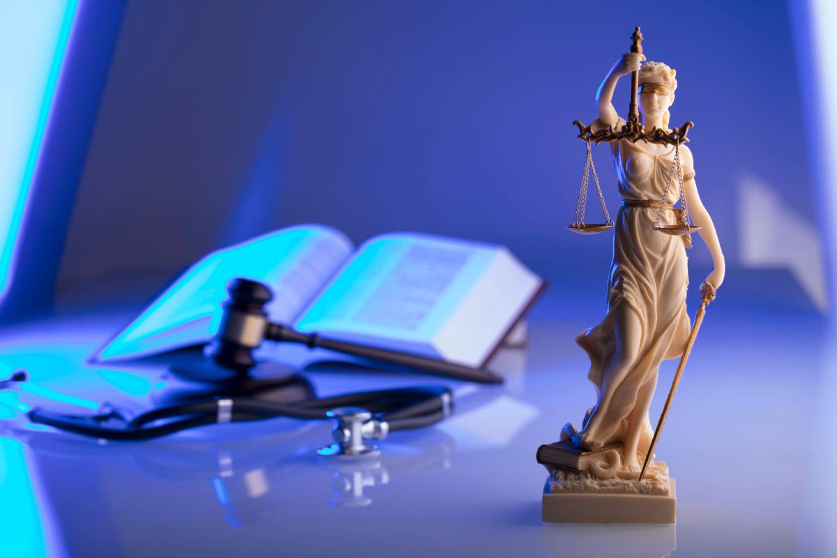 Personal injury law concept justice scales and medical textbook in background