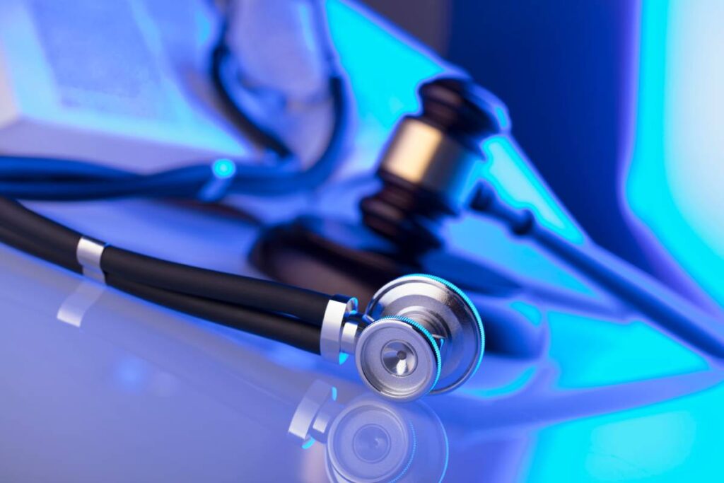 Shiny stethoscope in front of judges gavel personal injury law concept
