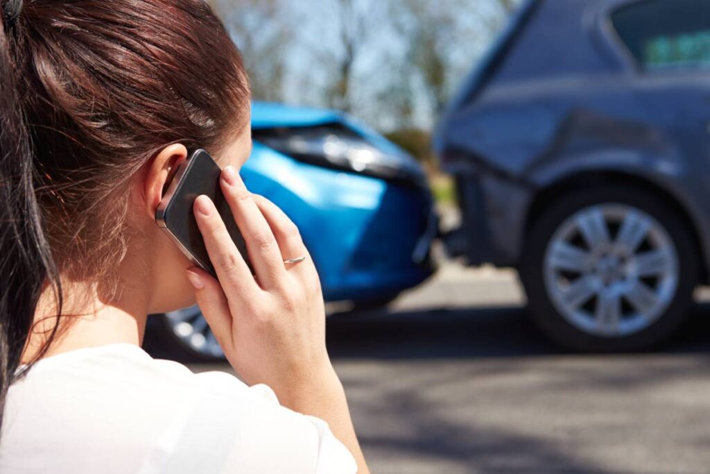 Woman on telephone reporting car accident claim in California 
