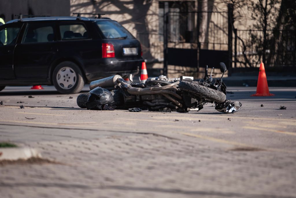 Motocicleta negra siniestrada tirada en el suelo tras un accidente