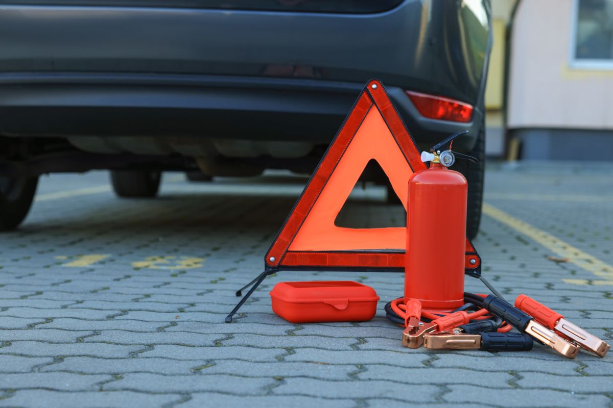 Close up of emergency warning sign and car safety kit equipment on ground