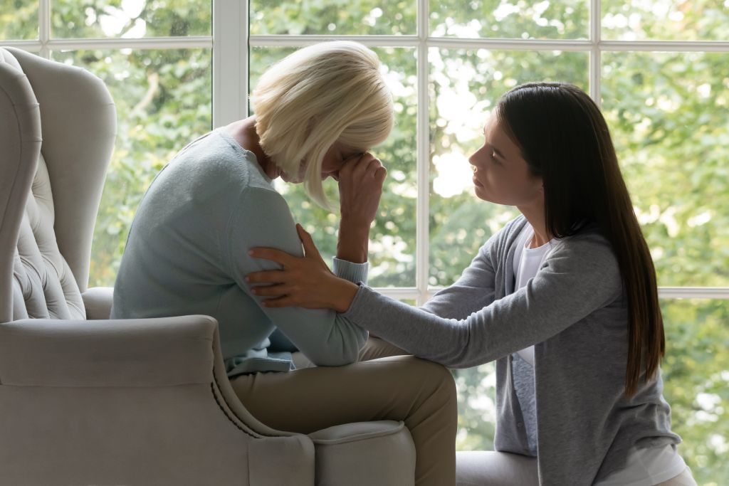 Young woman soothing a distressed older woman after wrongful death accident in California