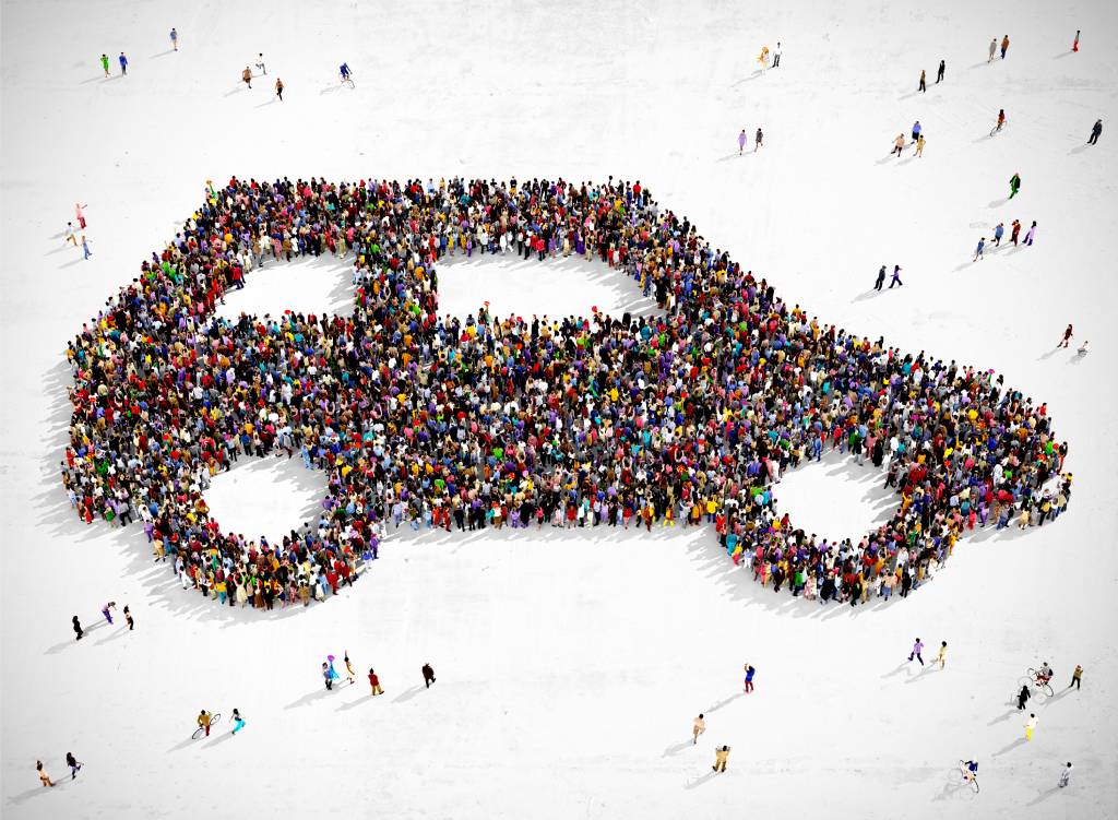 A large, diverse group of people creating the image of a car, representing differing California car crash statistics.