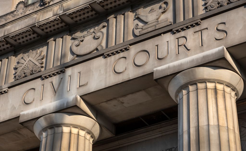 Primer plano de las palabras "CIVIL COURTS" con la parte superior de dos columnas griegas debajo y una fachada encima, del famoso edificio de los tribunales civiles de San Luis, Misuri.