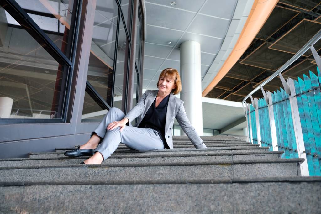 Una mujer que se ha caído en las escaleras y se está sujetando la rodilla.
