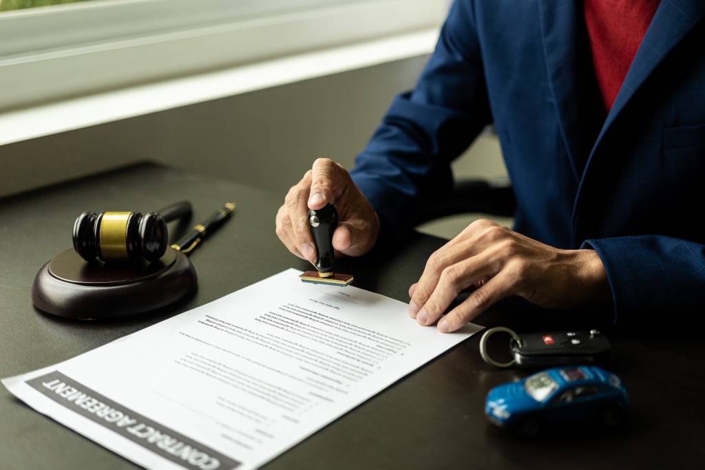 Concept image of a California car accident lawyer poring over a contract agreement for a potential client to sign.